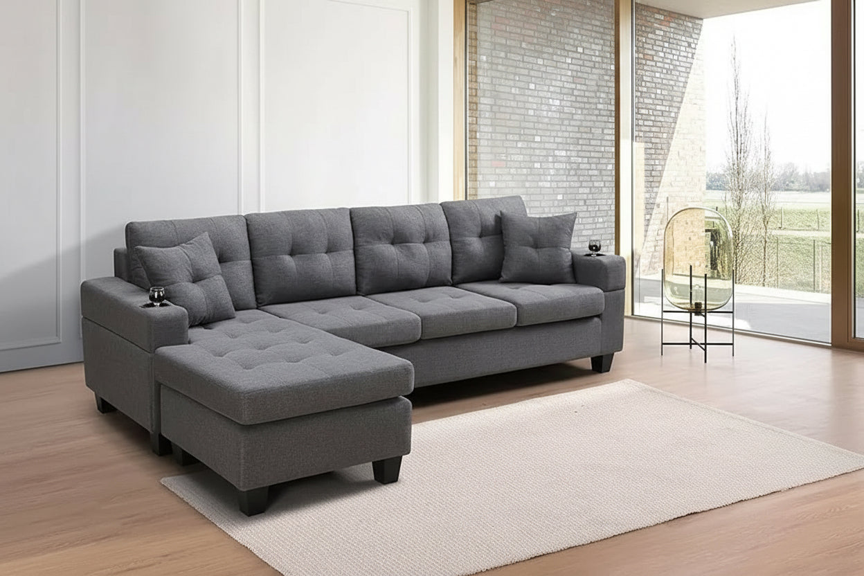Gray sectional sofa in a living room with large windows and a rug.