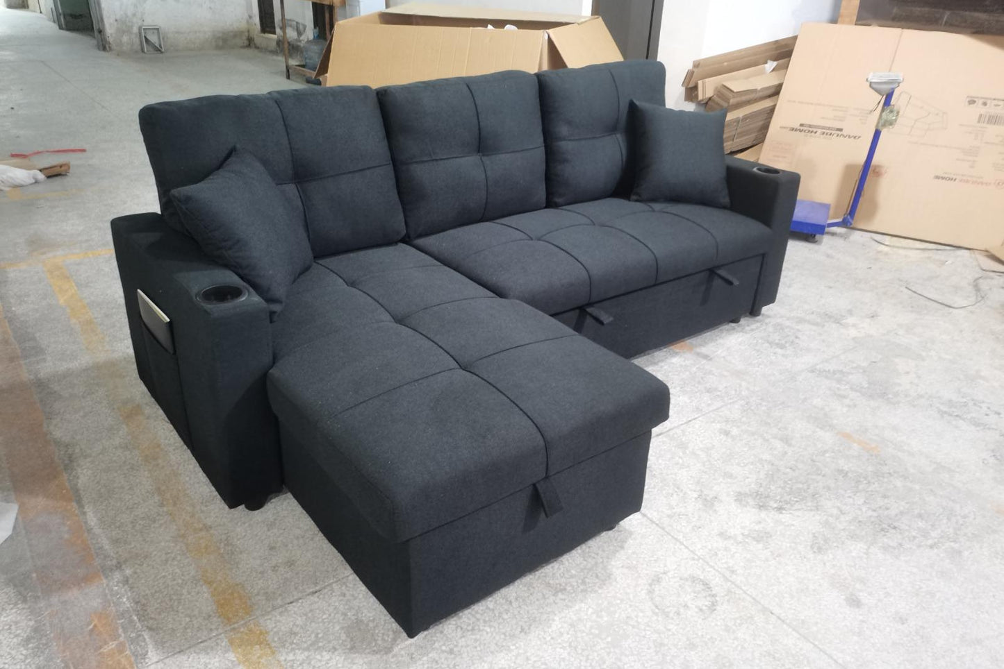 Angled view emphasizing the hidden storage compartment and the comfortable pull-out bed fully extended from the 85-inch sectional.