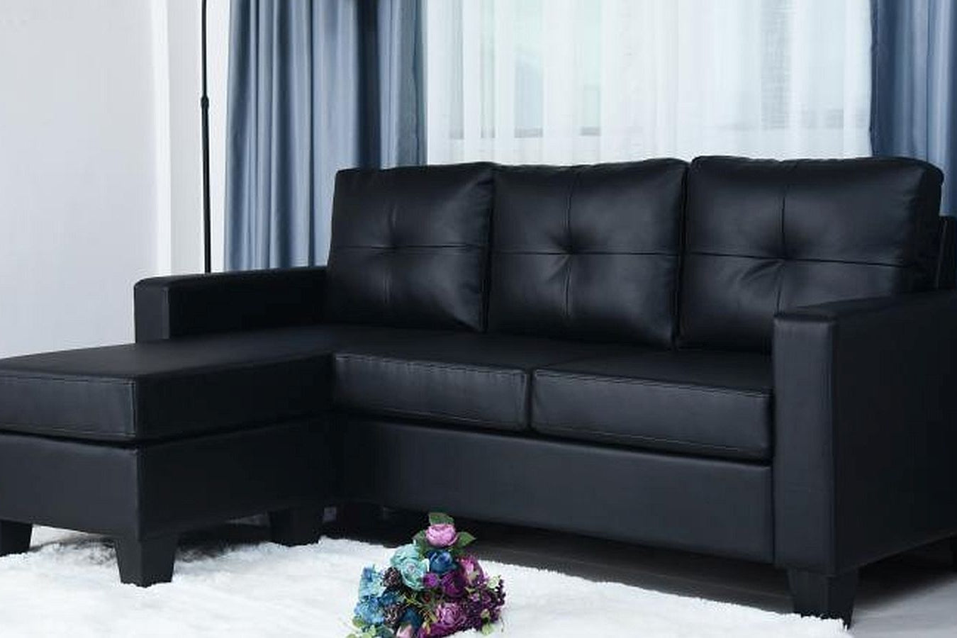 Full view of the Anna Black PU Leather Sectional Sofa, showcasing the sleek, dark upholstery, L-shape configuration, and seating with detachable cushions.