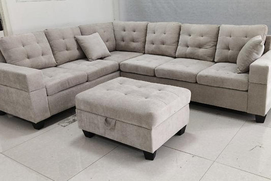 Full view of the Emerson Beige Velvet Reversible Sectional Sofa, showcasing the neutral upholstery and the versatile matching ottoman placed next to the chaise.