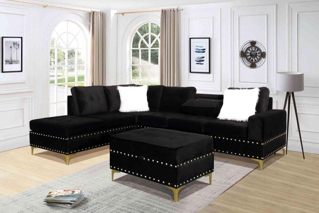 Full view of the Ivy Black Velvet Reversible Sectional Sofa, showcasing the plush fabric and the versatile matching storage ottoman placed next to the chaise.