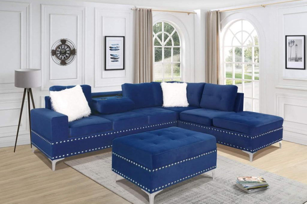 Full view of the Ivy Blue Velvet Reversible Sectional Sofa, showing the plush upholstery, storage ottoman, and the folded-down console with cup holders.