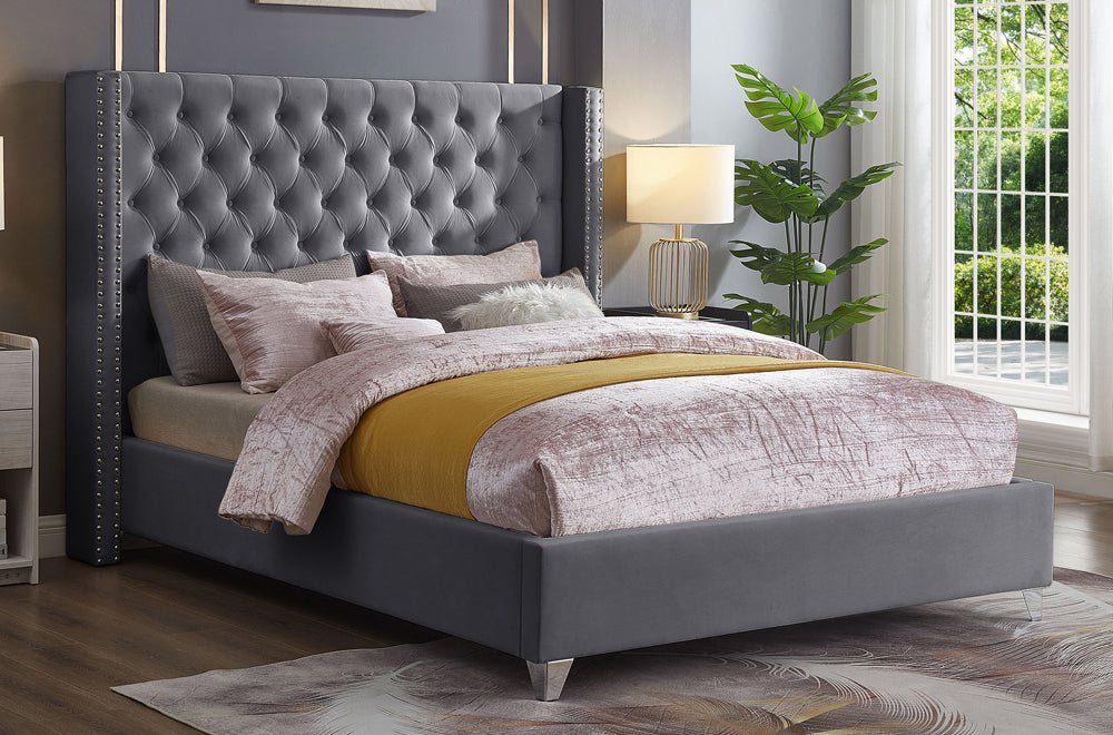 Luxurious velvet platform bed with deep tufted headboard, nailhead wings, and chrome legs