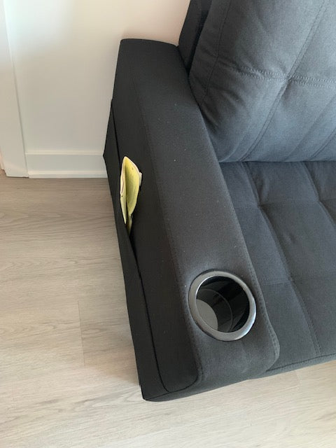 Close-up view highlighting the functional features, showing the loose ottoman used as a reversible chaise and the backrest folded down to reveal the cupholders.