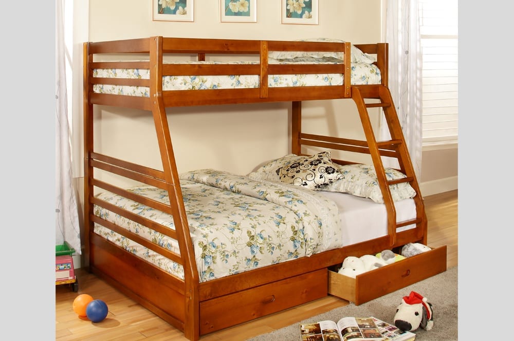 Close-up of the solid wood twin over full bunk bed with the two full-width under-bed storage drawers open, demonstrating concealed storage space.