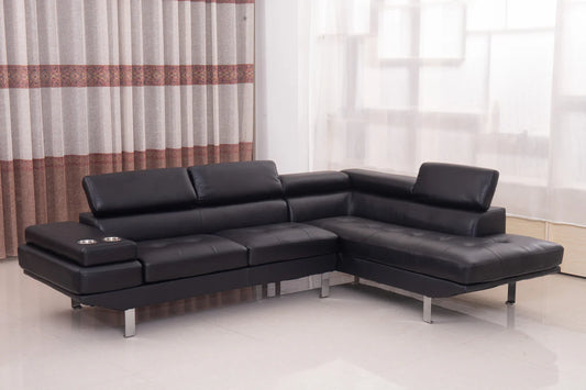 Black leather sectional sofa in a room with curtains and a light floor.